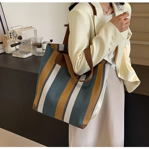 Close-up of the striped knit tote bag with durable canvas strap and leather corner protectors