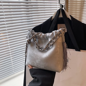 Makroaufnahme einer hellgrauen Falten-Beuteltasche mit Kette und elegantem Quasten-Detail