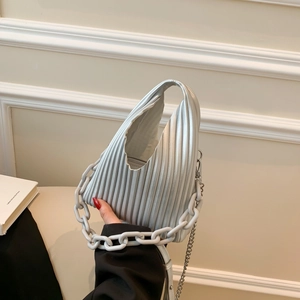 Detail view of silver pleated bag featuring chunky resin chain and metal shoulder strap