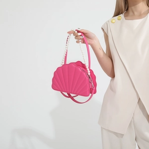 Detailed close-up of pink shell-shaped PU bag with pearl handle and metal zipper