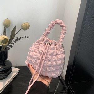 Close-up of pink cloud-shaped bucket bag featuring pleated bubble texture and chain strap