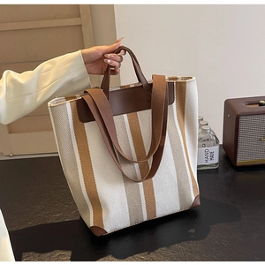 Close-up of contrast striped canvas tote bag with leather corner reinforcement detail