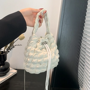 Close-up of a white pleated bubble bucket bag with drawstring and silver chain strap