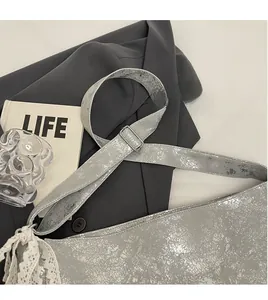 Detail of silver cracked leather bucket bag showing smooth adjustable shoulder strap