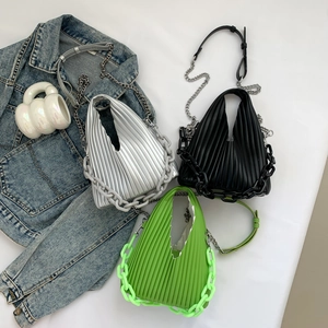 Flat lay of pleated PU crossbody bags in silver, black, and green with chunky chain straps