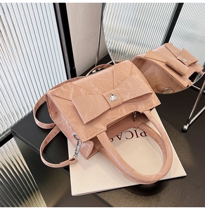 Detail of light pink marble pattern handbag with a large bow and heart crystal accent
