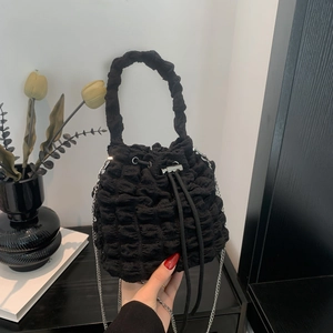 Detail of black cloud bucket bag showing unique bubble pleated texture and silver chain