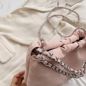 Detail der rosa gefalteten Wolkentasche mit matter Textur und Metall-Kettenriemen