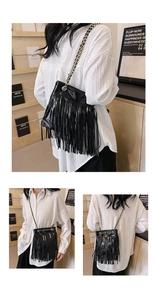 Détail d'un sac à franges en cuir noir brillant avec une bandoulière en chaîne élégante