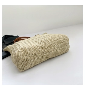 Détail de la texture de tissage en V serrée sur le sac seau en paille beige