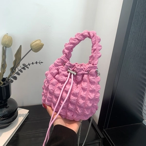 Detail of pink bubble cloud bag fabric with drawstring and silver chain strap