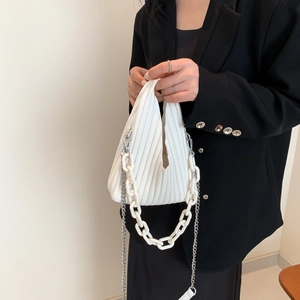 Detail view of white pleated PU bag with plastic decorative chain and metal strap