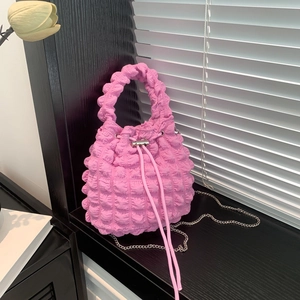 Detail of pink ruched bucket bag with bubble texture fabric and metal chain strap