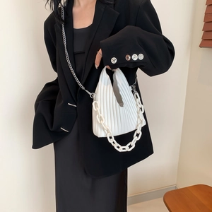 Detail of white pleated PU leather handbag with chunky chain handle and crossbody strap
