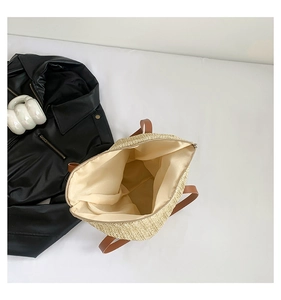 Détail du sac cabas en paille tissée avec poignées en similicuir brun et fermeture éclair