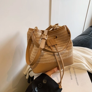 Détail du sac seau en paille tressée montrant l'artisanat fin et les finitions en cuir