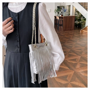 Détails d'un sac bandoulière argenté à franges avec texture PU et chaîne
