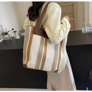 Detail of striped canvas tote bag showing high-quality stitching and textured fabric
