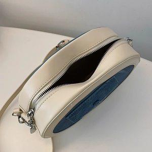 Top view of cream and blue crossbody bag showing inner space and silver zipper detail