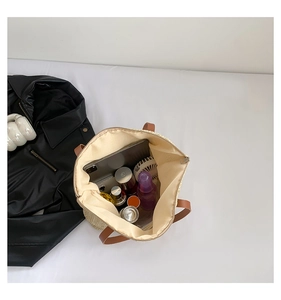 Vue de dessus du grand sac seau en paille avec doublure intérieure et objets du quotidien