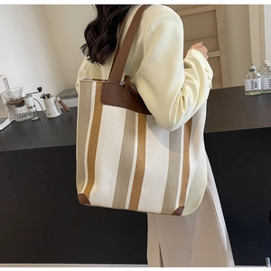Detail of the striped canvas tote bag with leather reinforcement and fabric shoulder strap