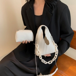 Close-up of white accordion pleated handbag set with resin chain and metal strap