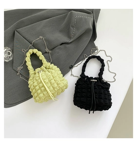 Detail view of mini bubble pleated cloud bags in lime and black with chain straps
