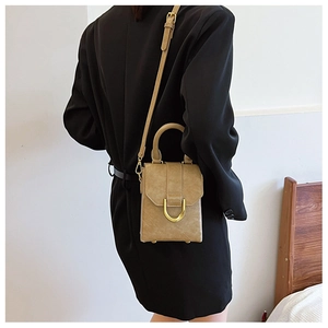 Detail of khaki leather mini bag with gold U-shaped hardware and adjustable shoulder strap