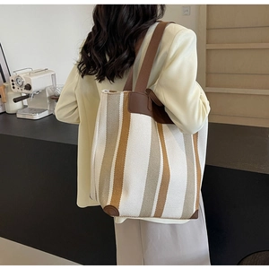 Close-up of contrast stripe canvas tote bag with brown leather trim details