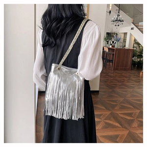 Détail du sac à bandoulière argenté métallisé avec de longues franges et chaîne dorée