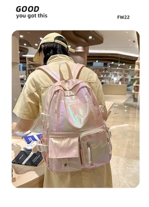 Detail view of pink holographic backpack with metal texture and front flap pocket design