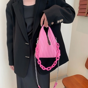Detailed view of pink pleated accordion bag with textured PU leather and dual chain straps