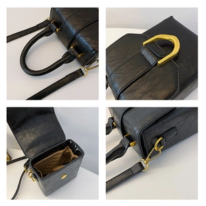 Close-up of black pleated leather handbag with gold hardware and striped fabric lining