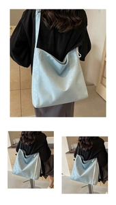 Detail of light blue glossy tote bag featuring elegant white lace trim on the side panel