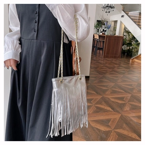 Détail du sac argenté à franges métalliques avec de longs glands et bandoulière chaîne