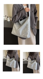 Detailed macro view of silver metallic crackle texture and white lace ribbon on bucket bag