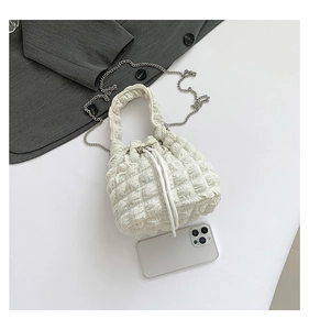 Detail of white bubble texture bucket bag with silver chain strap and drawstring closure