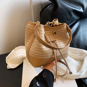 Détail du sac seau en paille tressée avec coutures en cuir et fermeture à cordon