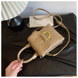 Top view of a khaki cracked leather mini crossbody bag with a gold metal ring clasp