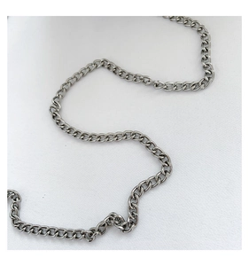Detailed macro view of the silver metal curb chain accessory for cloud underarm bag
