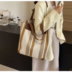 Detailed view of canvas tote bag with brown stripes in a stylish cafe setting