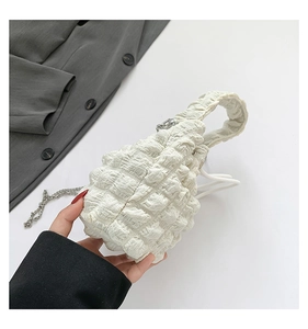 Close-up of textured ruched fabric on mini cloud bag with silver metal chain strap