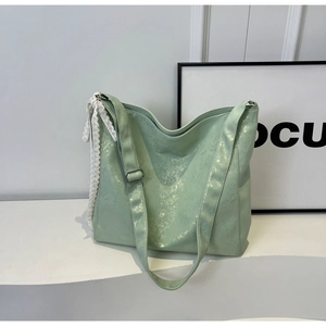 Detailed close-up of light green bucket bag with white lace trim and pearl finish leather