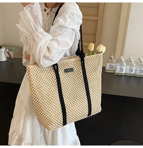 Detail of hollow woven tote bag with black rope handles and elegant summer resort style