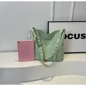 Spacious mint green bucket bag showing large capacity with a tablet inside