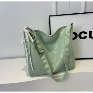 Detailed macro view of light green pearl finish bag with elegant white lace ribbon detail