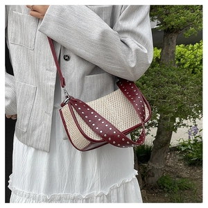 Détail du sac bandoulière bohème tressé avec cuir bordeaux et rivets métalliques argent