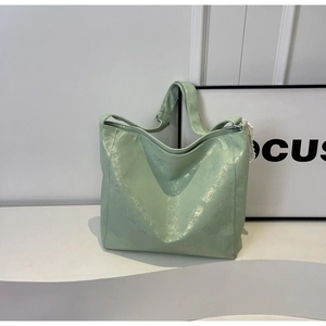 Detail of light green bucket bag showing soft pleated texture and metallic pearlescent finish