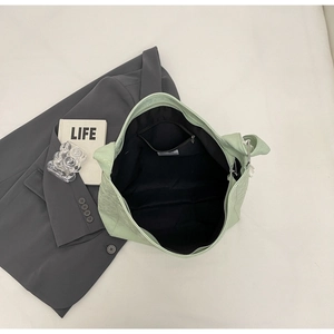 Detail view of large light green bucket bag showing inner zipper pocket and fabric lining