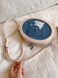 Pink round crossbody bag with denim cat embroidery and adjustable chain strap